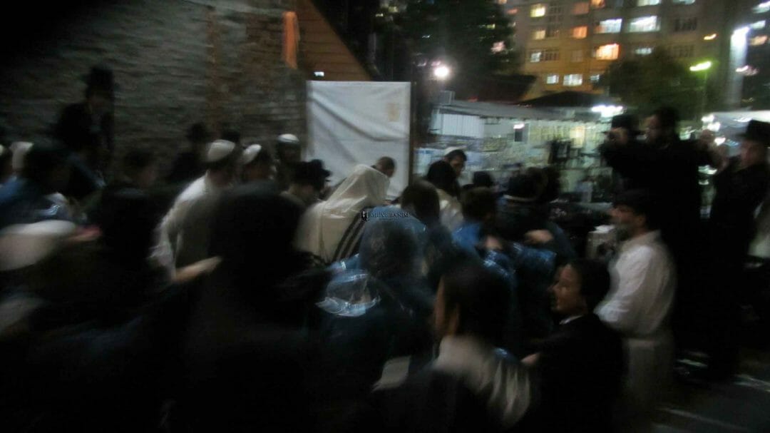 המונים מלווים את הגה"צ הרב אליעזר ברלנד שליט"א מביתו באומן למניין המרכזי בקלויז של חסידי ברסלב - התמונה באדיבות אהרון סולמונוביץ'