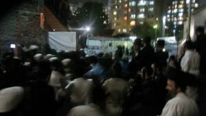 המונים מלווים את הגה"צ הרב אליעזר ברלנד שליט"א מביתו באומן למניין המרכזי בקלויז של חסידי ברסלב - התמונה באדיבות אהרון סולמונוביץ'