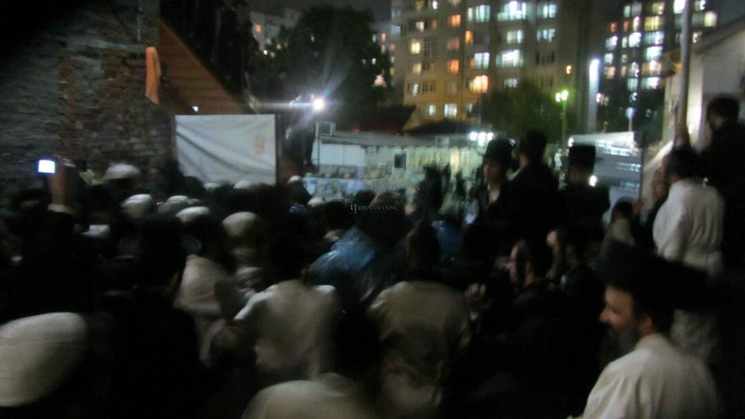 המונים מלווים את הגה"צ הרב אליעזר ברלנד שליט"א מביתו באומן למניין המרכזי בקלויז של חסידי ברסלב - התמונה באדיבות אהרון סולמונוביץ'